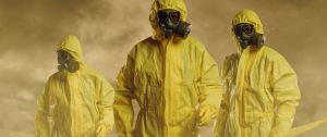 Trois exterminateurs dans des combinaisons jaunes, avec de la fumée