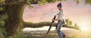 un homme assis sur une branche qu'il est en train de scier