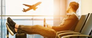 un homme regarde un avion s'envoler dans un aéroport