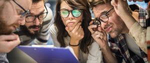Un groupe de jeunes employés dubitatifs face à un document mystère