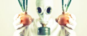 Une personne portant un masque à gaz tenant des oignons