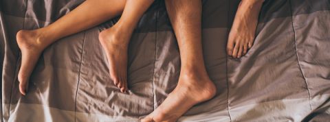 Les pieds d'un couple dans un lit