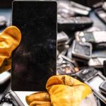deux mains gantés démontent un smartphone