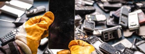 deux mains gantés démontent un smartphone