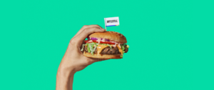Une main qui tient un hamburger sur un fond vert