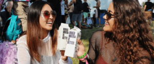 Deux jeunes femmes qui boivent de l'eau à un festival