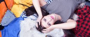 Femmes stressée allongée sur une pile de vêtements