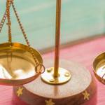 Une balance sur un fond vert et rose