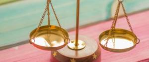 Une balance sur un fond vert et rose