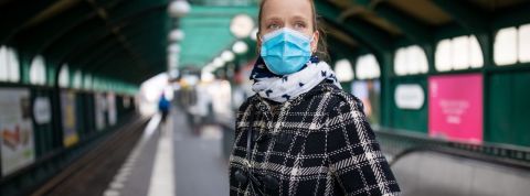 Une masque avec un masque qui attend le métro