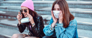 Deux jeunes filles portant un masque sur des escaliers