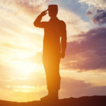 Un officier faisant un salut sur un fond de soleil couchant