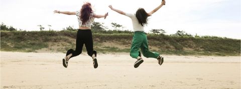 Deux femmes qui sautent en l'air sur une plage