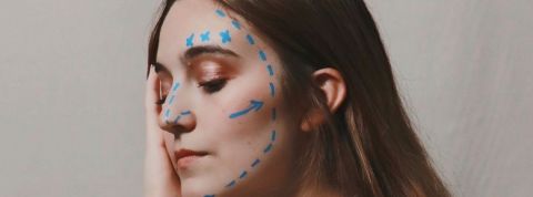 Une femme avec du crayon sur le visage comme avant une opération chirurgicale