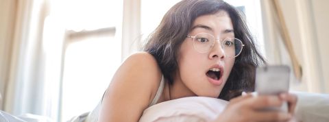 Une jeune femme panique devant son smartphone