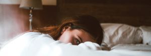 Femme fatiguée allongée sur le bord de son lit