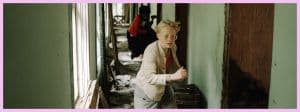 Un enfant blond qui court dans un couloir vert