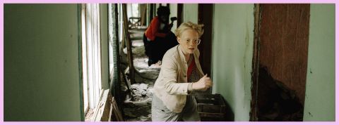 Un enfant blond qui court dans un couloir vert