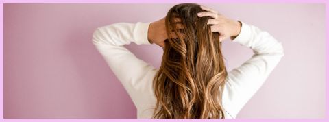 Une femme de dos avec de longs cheveux bruns