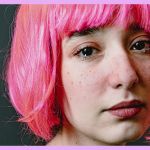 Une jeune fille en train de pleurer avec une perruque rose