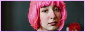 Une jeune fille en train de pleurer avec une perruque rose