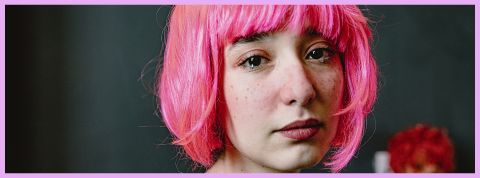 Une jeune fille en train de pleurer avec une perruque rose