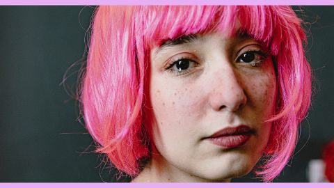 Une jeune fille en train de pleurer avec une perruque rose