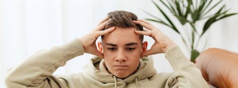 jeune homme déprimé, se prenant la tête