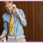 Un homme au téléphone debout derrière son bureau