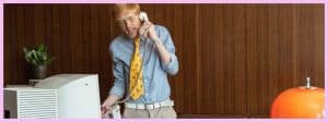 Un homme au téléphone debout derrière son bureau