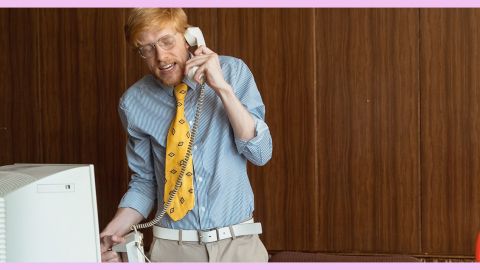 Un homme au téléphone debout derrière son bureau