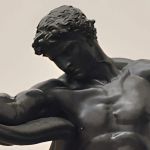 une statue d'homme tenant un serpent à bout de bras