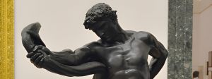 une statue d'homme tenant un serpent à bout de bras