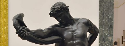 une statue d'homme tenant un serpent à bout de bras