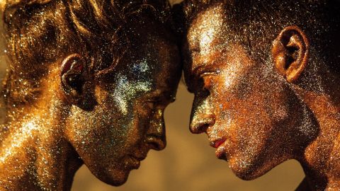 Couple face à face couvert de paillettes dans les tons or