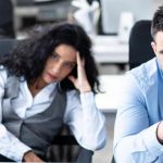 2 employés à l'air abbatu devant leur bureau