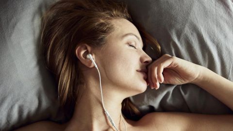Une femme dort avec ses écouteurs