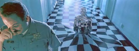 Au premier blanc un policier et derrière lui un robot qui sort du sol