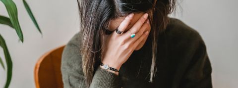 Une femme déprimée, la tête dans les mains