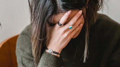 Une femme déprimée, la tête dans les mains