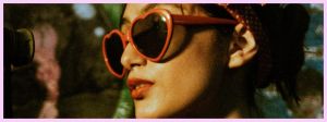 Une femme qui porte des lunettes rouge en forme de cœur