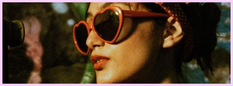Une femme qui porte des lunettes rouge en forme de cœur
