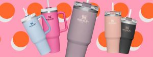 Des Stanley cups de différentes couleur sur un fond pop rose et orange