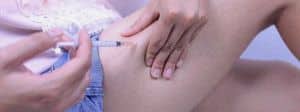 Une personne en train de se faire une piqure dans la cuisse