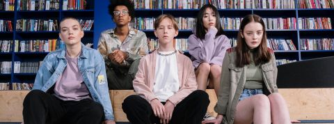 Cinq jeunes ados, filles et garçons, dans une bibliothèque