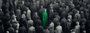 Une foule grise et un homme en costume vert au milieu