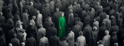 Une foule grise et un homme en costume vert au milieu