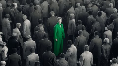 Une foule grise et un homme en costume vert au milieu