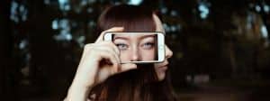 une fille qui pose avec un smartphone sur le côté de sa tête