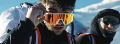 un homme en tenue d'alpiniste regarde la caméra